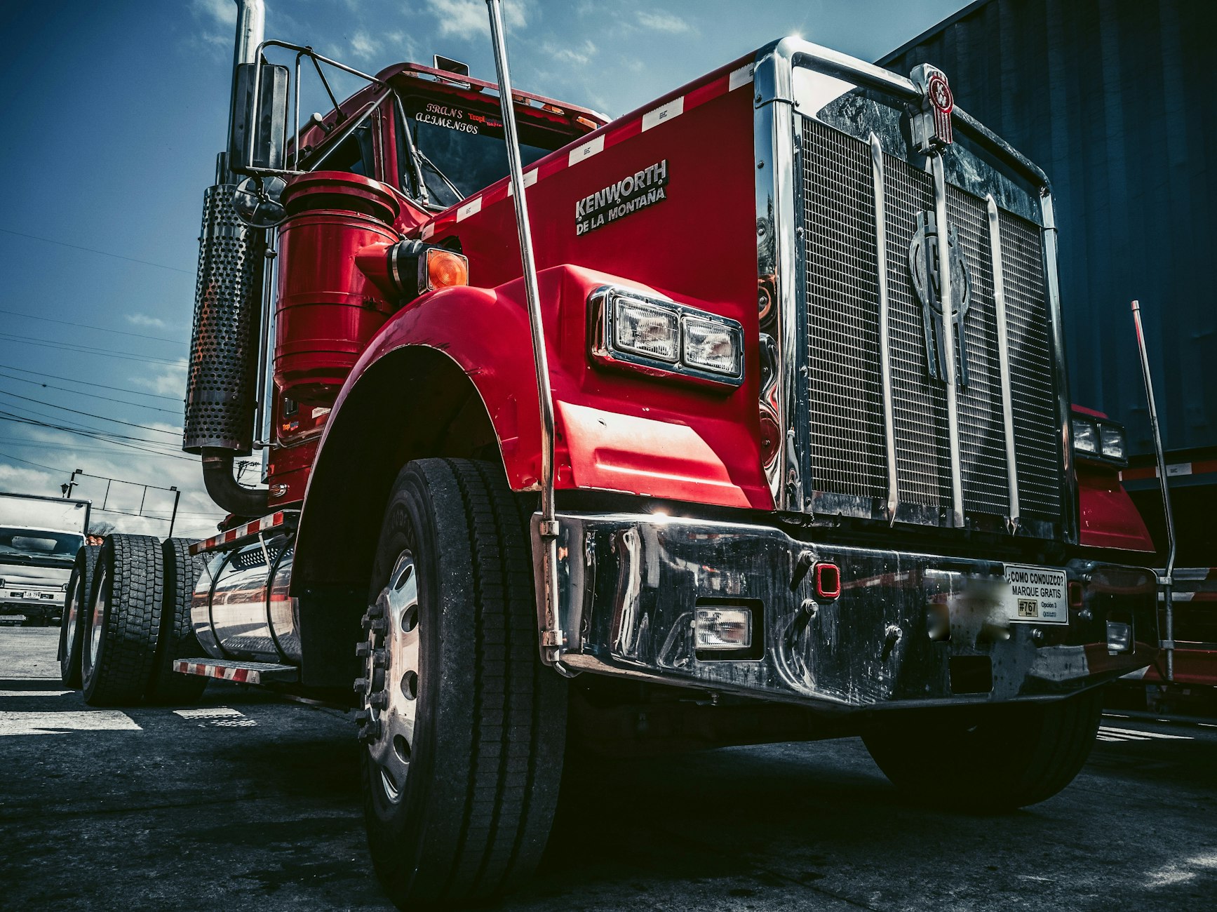Red semi truck parked at a depot