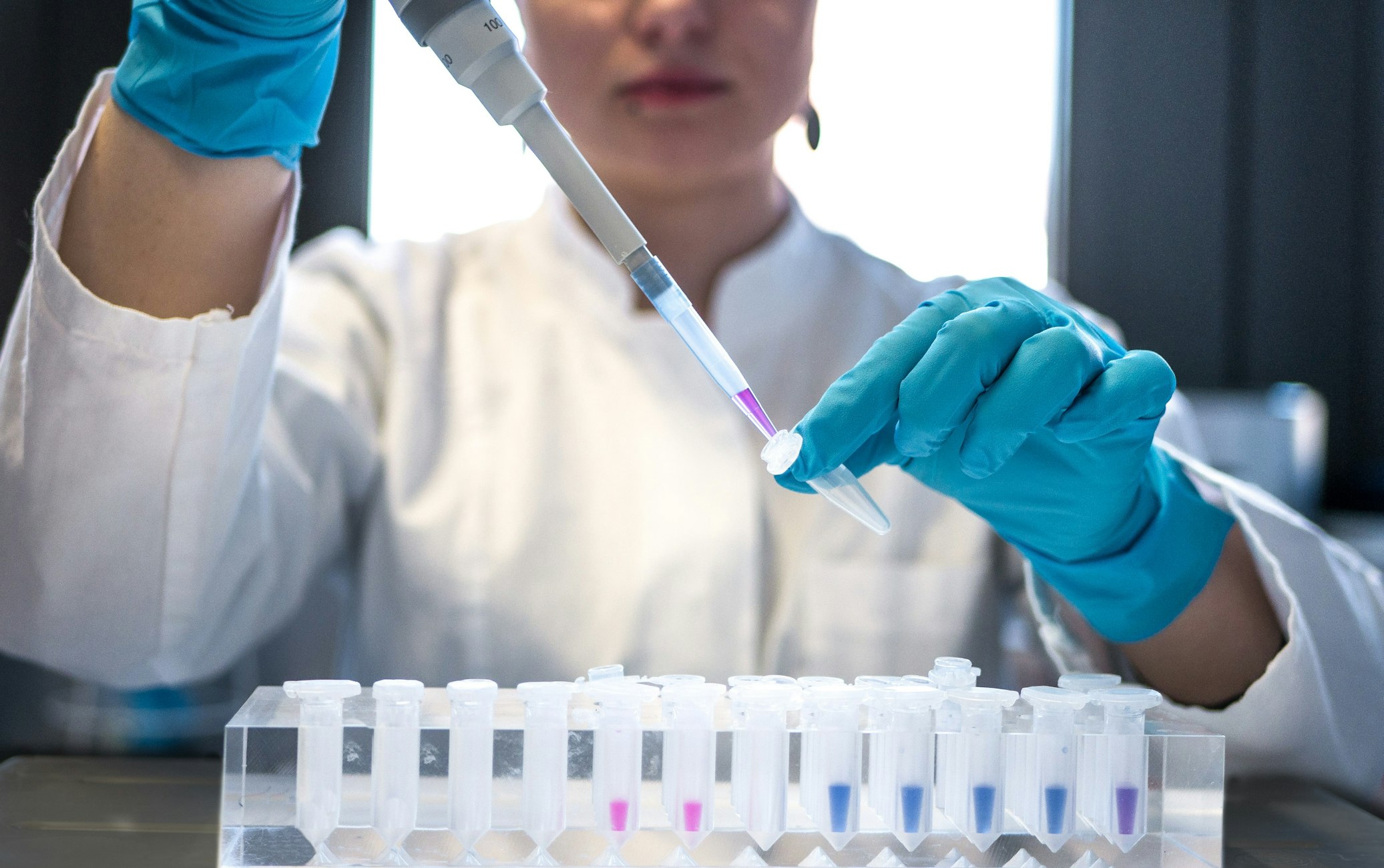 Lab technician pipetting samples into test tubes
